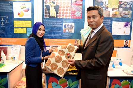 Prof. Madya Dr. Nazlina bersama Timbalan Pengarah Bahagian Promosi dan Pemasaran Inovasi, Dr. Mohamad Fakri Zaky Ja`afar,  menunjukkan inovasi Utilizing Sago Waste as a Natural Ecopaste in Textile Prints yang telah berjaya menambat hati juri.